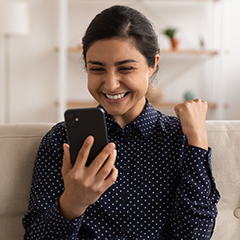 persona sonriendo al teléfono señalando sí