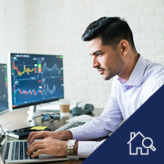 a person working on a computer looking at stock data