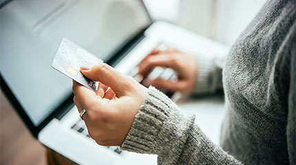 Person entering credit card information into their laptop