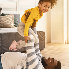 Smiling child being held up by loving parent