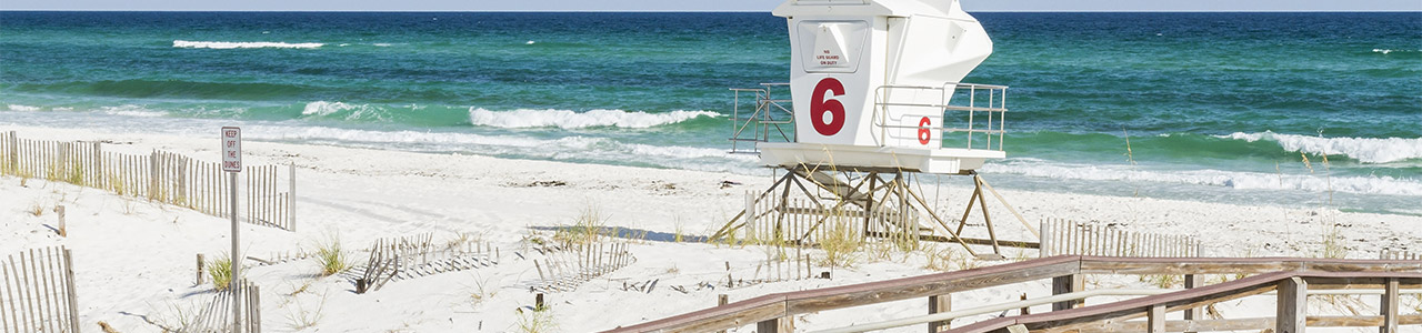 A lifeguard shack on a white beach.