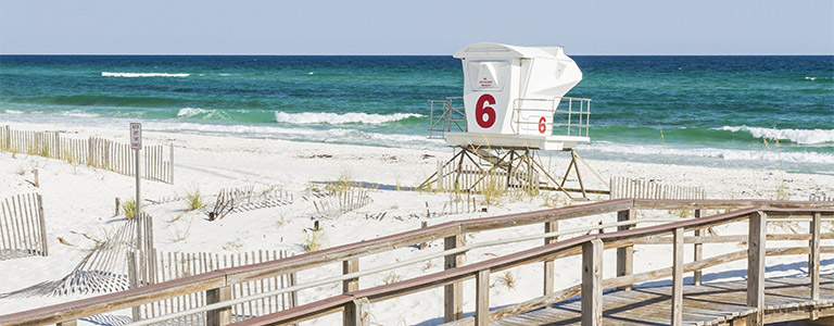 A lifeguard shack on a white beach.