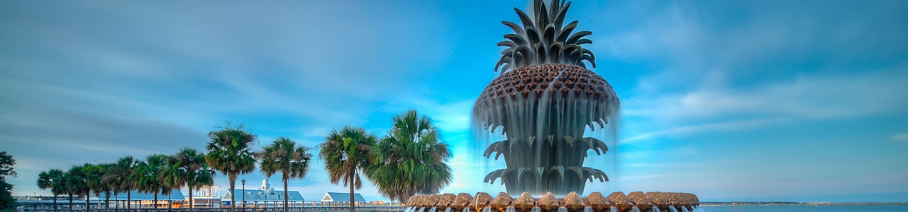 A pineapple-shaped fountain with the South Carolina shoreline in the background.