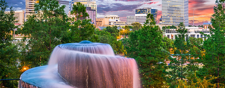 A large fountain with trees behind it.