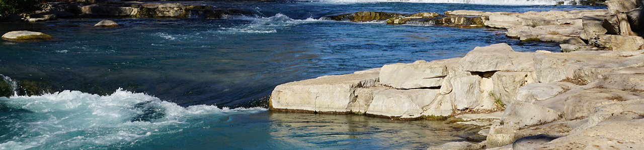 A river flows along a rocky shore.