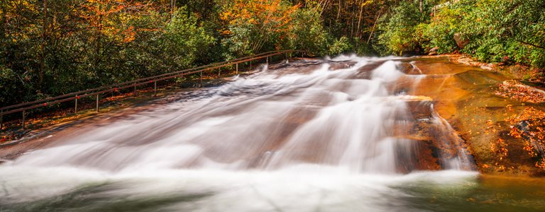 A river runs through the colors of the autumn foliage.