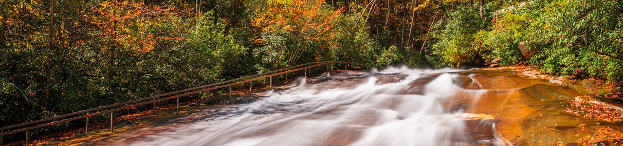 A river runs through the colors of the autumn foliage.